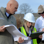 Image of Nally Homes team members, Mike Nally, Macie Parcells, and Conor Nally working together outside.